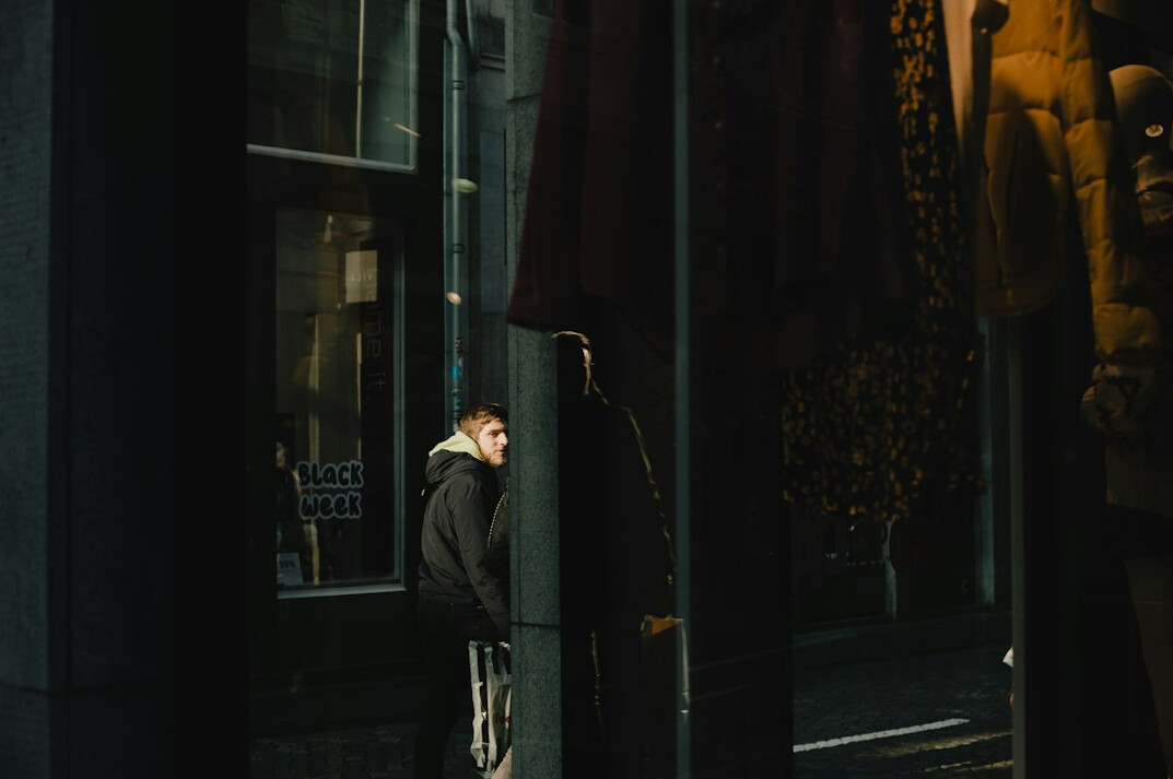 man in long coat in store